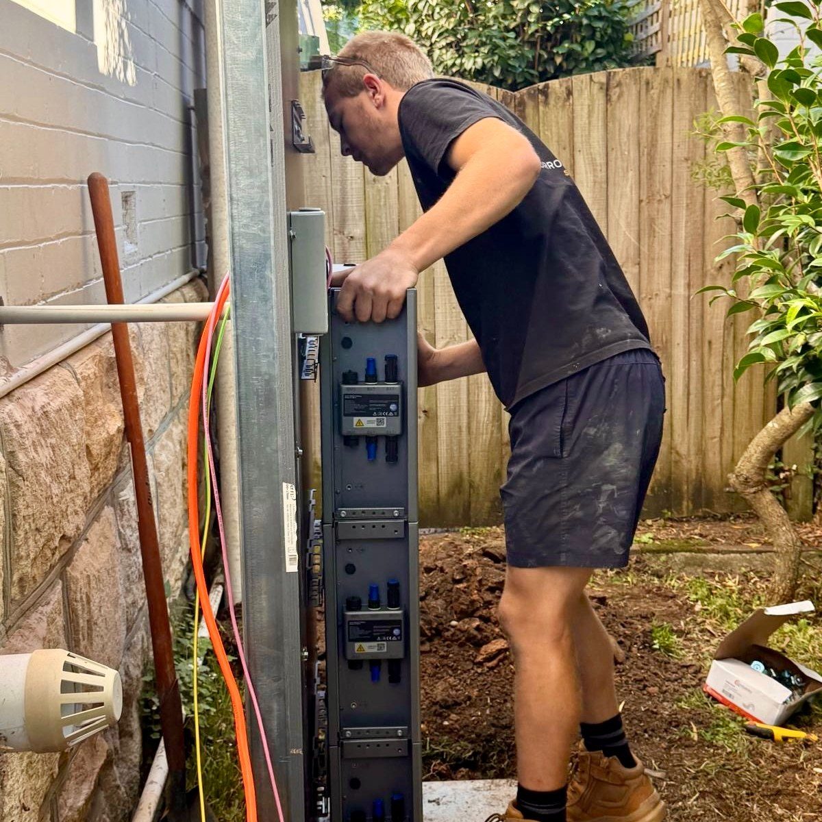 Borrow Electrical wiring a new switchboard enclosure on site in a backyard